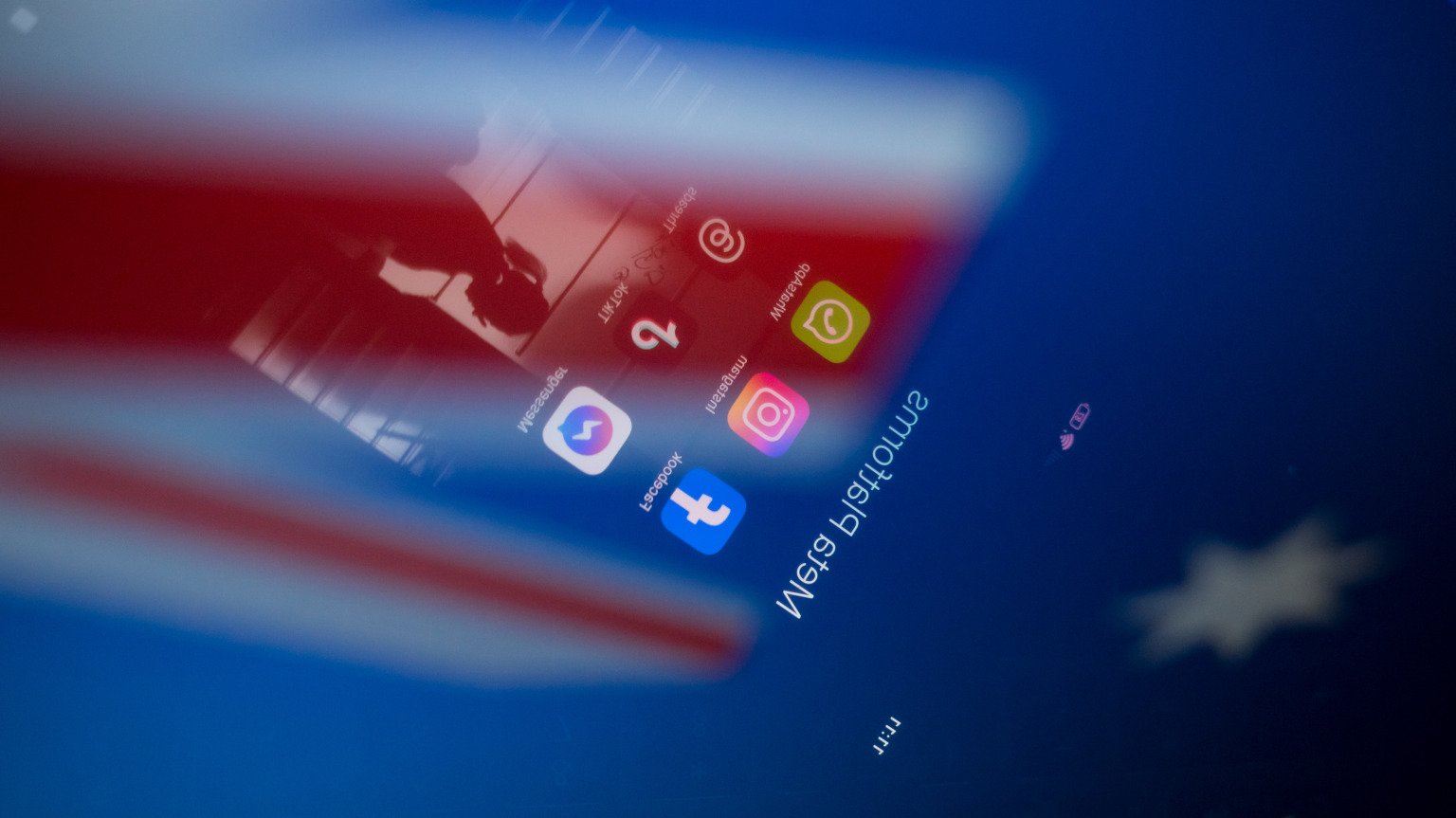 Social network logos display on a smartphone screen and the Australian flag appears on a computer screen in this photo illustration in Athens, Greece, on November 21, 2024. The Australian government proposes a ban on social media for all citizens under 16. Citing the success of recently introduced restrictions on mobile phones in Australian schools, the prime minister announces the ban by declaring that it is doing harm to children and he is calling time on it.