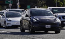 Tesla vehicles drive on the street on February 2, 2024 in San Bruno, California. 