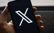 A person looks at X on their cell phone.