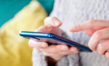 A woman holds a smartphone in her hands. 