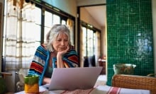 A woman peers at her laptop.