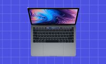 a 2019 MacBook Pro with touch bar on purple check background