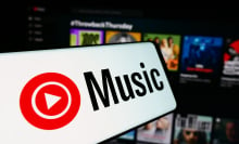 A mobile phone with the logo of American music streaming service YouTube Music is seen in front of business website.