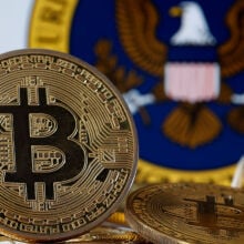 , A visual representation of the digital cryptocurrency Bitcoin is displayed in front of Securities and Exchange Commission (SEC) logo.