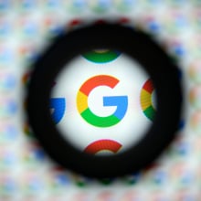 A magnified Google logo on a blurry background.