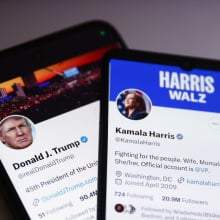 Two phones display the X/Twitter accounts of presidential candidates Donald Trump and Kamala Harris.