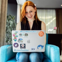 woman working on laptop covered in stickers