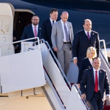 Elon Musk and members of Donald Trump's team walk out of a private plane. 