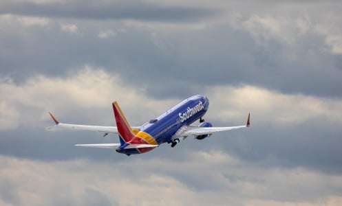 Southwest airplane flying in sky with clouds