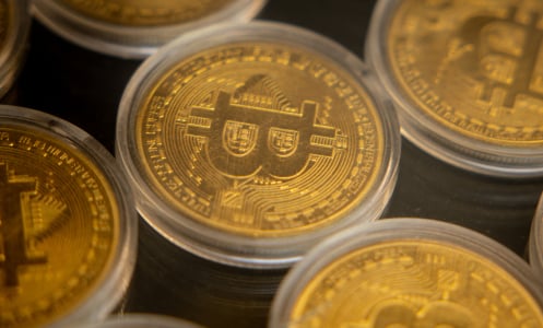 Gold coins with the Bitcoin "B" stamped on them.