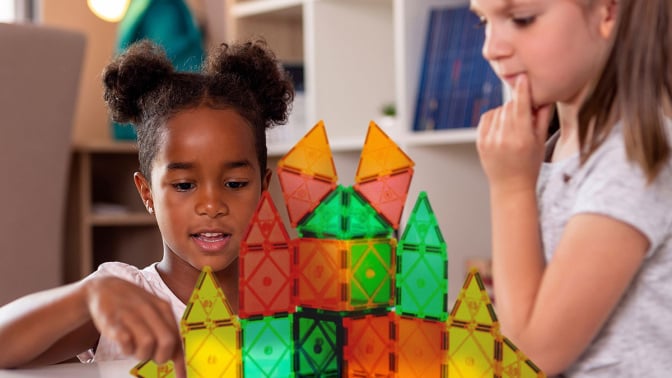 two children playing with magnetic blocks