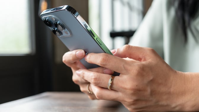 woman's hands holding an iPhone 13 Pro