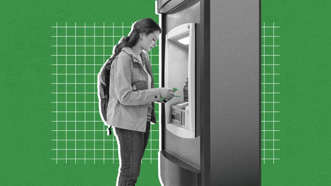 A woman has cash at an ATM machine. 