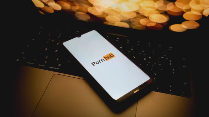 The Pornhub logo is being displayed on a smartphone screen