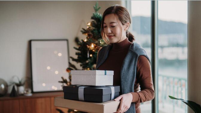 Young person packing gifts for Christmas - stock photo