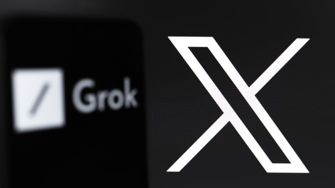 The Grok logo appears on the screen of a smartphone, and in the background, the logo of the social network X (formerly Twitter) is on the computer screen, in Reno, United States, on November 12, 2024. Grok is an artificial intelligence chatbot generative technology developed by xAI, with an initiative from Elon Musk. The company tests a free version of the service that will be available soon.