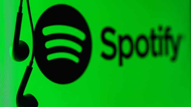 the spotify logo with headphones dangling next to it