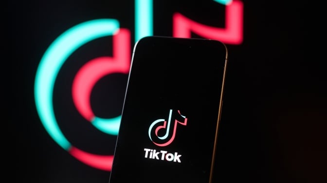 TikTok logo on a smartphone and in the background.