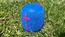 blue and pink ultimate ears wonderboom 3 speaker in the grass