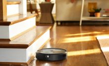 An iRobot Roomba j7+ robot vacuum sweeping a living room