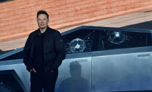 Tesla co-founder and CEO Elon Musk stands in front of the shattered windows of the newly unveiled all-electric battery-powered Tesla's Cybertruck at Tesla Design Center in Hawthorne, California on November 21, 2019.