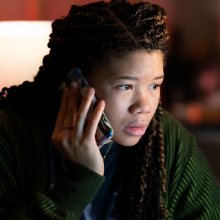 A teenage girl speaks on the phone. 