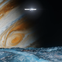 A conception of the Europa Clipper spacecraft flying by the Jovian moon, Europa, with dominant Jupiter in the distance.