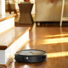 An iRobot Roomba j7+ robot vacuum sweeping a living room