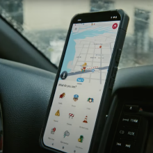 Waze app open on a smartphone mounted on a cab dashboard.