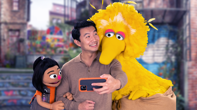 Actor Simu Liu welcomes new muppet Ji-Young to the neighborhood on Sesame Street with Big Bird.