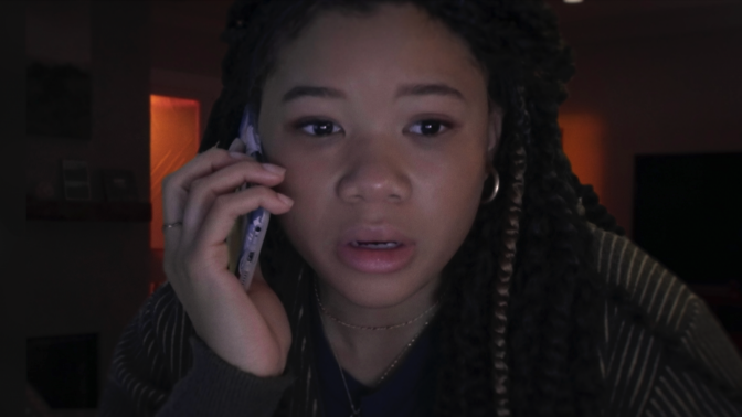 A girl answers the phone crying. 