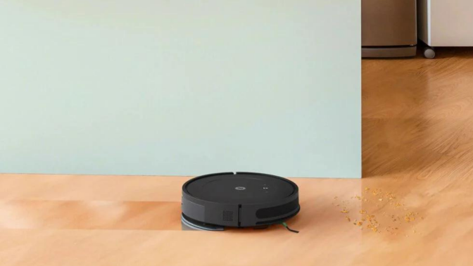 Roomba Combo Essential robot vacuum mopping hardwood floor with kitchen island in background