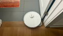 Roborock Qrevo Master robot vacuum mopping hardwood and tile floor by door